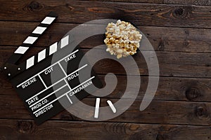 Filmmaking concept. Movie Clapperboard. Cinema begins with movie clappers. Movie clapper on a wooden background and popcorn