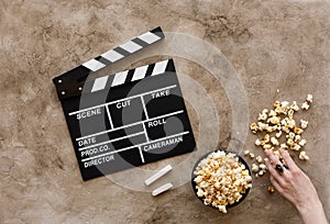 Filmmaking concept. Movie Clapperboard. Cinema begins with movie clappers. Movie clapperboard on a textural background and popcorn