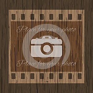 Filmstrip template with photo camera on wooden background