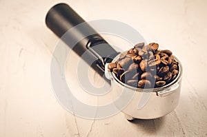 Filter holder and roasted beans coffee/Filter holder and roasted beans coffee on a concrete background. Selective focus and