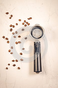 Filter holder and roasted beans coffee/ Filter holder and roasted beans coffee on a concrete background. Top view