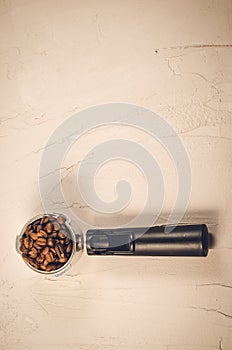 Filter holder and roasted beans coffee/ Filter holder and roasted beans coffee on a concrete background. Top view and copyspace