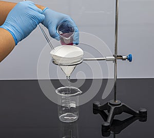 Filter paper in laboratory. Scientists are chemical filtration by filtering through filter paper in a glass funnel, Close up. Phar