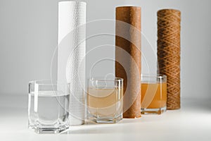 Filter system for water treatment with glasses of clean and dirty water on bright background