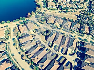 Filtered image aerial view new lakeside suburban house with bright autumn orange color near Dallas