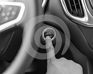 Filtered image hand pressing the start stop button on keyless car
