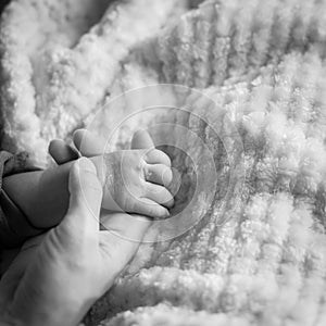 Filtered image of tiny baby hand in her mother palm for love and protection concept