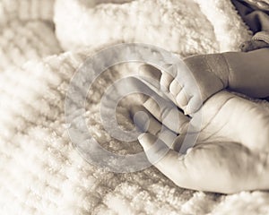 Filtered image of tiny baby hand in her mother palm for love and protection concept