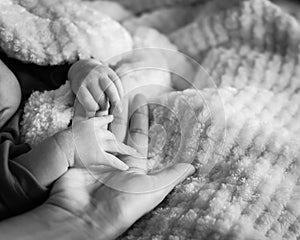 Filtered image of tiny baby hand in her mother palm for love and protection concept