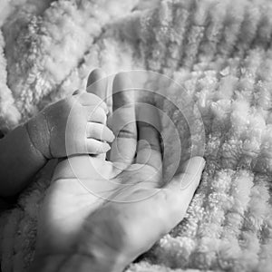 Filtered image of tiny baby hand in her mother palm for love and protection concept