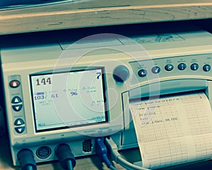 Filtered tone close-up fetal monitor with baby heart beats at labor room hospital