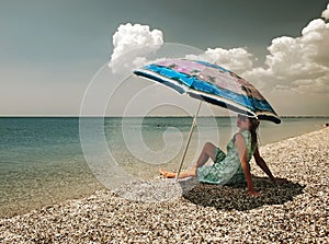 Filtered view of a girl, umbrella and beach