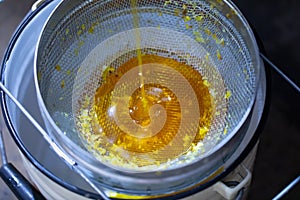 Filtering honey through a fine and large sieve