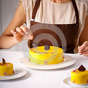 Final embellishment of big yellow cake. photo