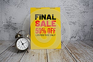 Final Sale 50% off text message and alarm clock on wooden background