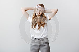 Finally can spend time for myself. Relaxed attractive female student in fashionable headband and casual t-shirt, holding