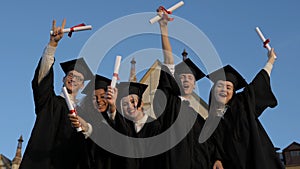 Finally free. Group of cheerful students wearing graduation gown
