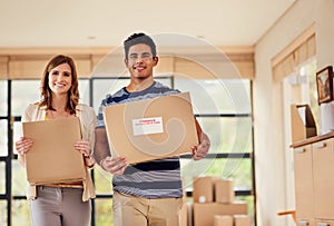 Finally, the last of the boxes. Portrait of a smiling young couple carrying boxes on moving day.