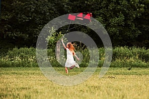 Finally it`s summer. Happy girl in white clothes have fun with kite in the field. Beautiful nature