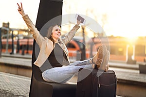 Finally on vacation. Woman celebrating at train station.