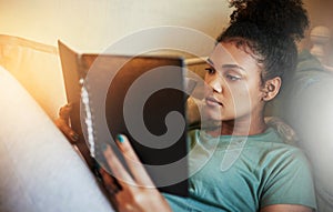 Finals are fast approaching. High angle shot of a young female student studying at home.