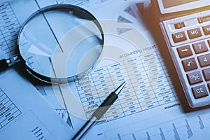 finance accounting concept. pen and calculator with magnifying g