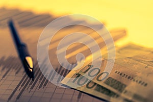 Finance background with money, stock market chart, graph and pen. Economy and business concept.