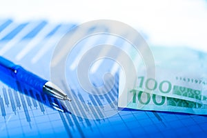 Finance background with money, stock market chart, graph and pen. Economy and business concept.