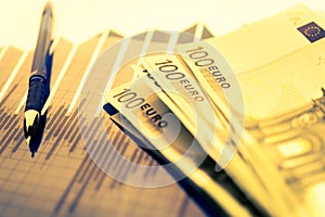 Finance background with money, stock market chart, graph and pen. Economy and business concept.