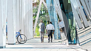 Finance, business and cooperation concept. Two successful businessmen are talking on the street. Office workers are