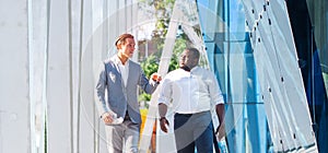 Finance, business and cooperation concept. Two successful businessmen are talking on the street. Office workers are