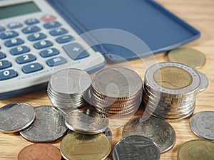 Finance business, pile of coins, baht money and calculator on wood background