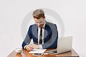 Finance, business and wealth concept. Good-looking young male entrepreneur, employer sitting his office, reading