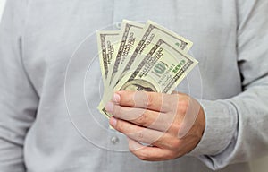 Finance, investment or money saving concept. Man holding paper us dollars