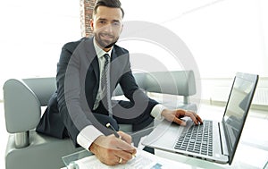 Finance manager working with business graphics on a laptop