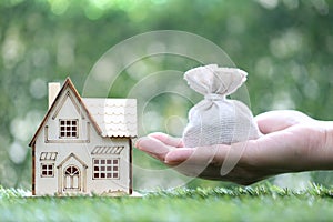 Finance, Model house with money bag on natural green background,Business investment and Save money for prepare in future concept