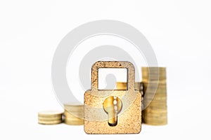 Finance, Money, Security and Saving Concept. Close up of wooden master key lock icon in front of stack of gold coins on white