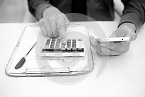 Finance person table`s or workplace`s close up a shot while he was doing some finance and loan-related work with cell phone, calcu