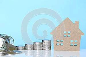 Finance, Stack of coins money and Model house on blue background, Business investment and real estate