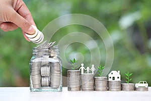 Finance, Stack of coins money and model house and model family on natural green background, Business investment growth and Save