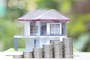 Finance, Stack of coins money and Model house on natural green background, Business investment and real estate