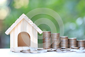 Finance, Stack of coins money and Model house on natural green background, Business investment and real estate