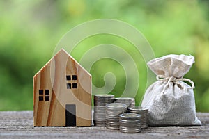 Finance, Stack of coins money and Model house on natural green background, Business investment and real estate