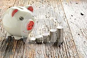 Finance stack coins and piggy bank on wood table