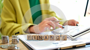 Finance text on cubes and working businesswoman with calculator
