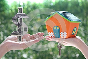 Finance,Woman holding usd dollar money and model house on natural green background,Business investment and real estate concept