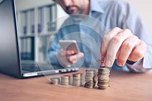 Finances and budgeting, businessman stacking coins photo