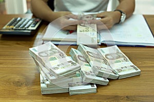 Finances Businessman counting Thai money with calculator on the