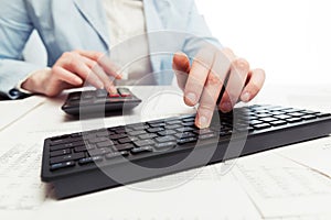 Financial accounting. Business woman using computer keyboard and calculator