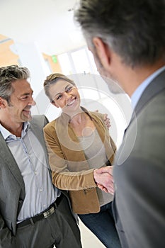 Financial advisor and clients handshaking after successful agreement